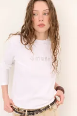 Remera blanca de manga larga con cuello redondo y diseño bordado en el pecho.