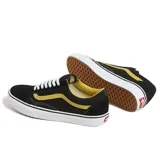 Championes Vans modelo Old Skool de caña baja, con diseño clásico de banda lateral Sidestripe. Confeccionados en una combinación de lona y ante, presentan un cuerpo negro con detalles en amarillo, cordones blancos y suela de goma blanca con la distintiva textura waffle.