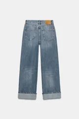 Pantalón de jean celeste de tiro medio, corte ancho y terminación con dobladillo.