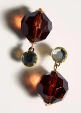 Pendientes cortos dorados con un cristal superior redondo y un dije colgante de cristal marrón translúcido con tallado facetado esférico.