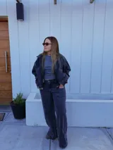 Pantalón de jean tiro medio con corte wide leg, color negro lavado, con bolsillos delanteros tipo cargo y costura vertical central en las piernas.