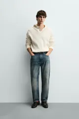 Sudadera de corte relajado confeccionada en tejido de algodón con textura waffle. Presenta cuello con capucha, cierre frontal parcial con botones y mangas largas con puños acanalados.