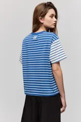 Remera de manga corta con diseño a rayas horizontales azules y blancas, corte relajado y cuello redondo.