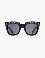 Lentes de sol Hawkers de acetato color negro con apliques de strass plateados en el frente del marco.