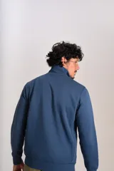 Buzo de cuello alto con cierre frontal parcial, manga larga y puños acanalados. Presenta el logo de la marca bordado en el pecho.