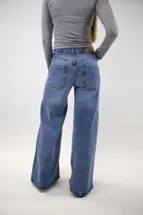 Pantalón jean baggy de color azul, con tiro medio, bolsillos traseros y diseño amplio en las piernas.