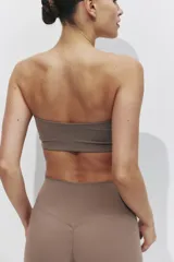 Top deportivo strapless de sujeción media, confeccionado en tejido funcional con tecnología SculptMove y DryMove para absorción de sudor. Presenta un diseño liso, sin cierre, con copas de relleno extraíbles.