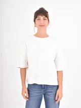 Remera negra de corte holgado, con cuello redondo y mangas cortas con dobladillo ancho.