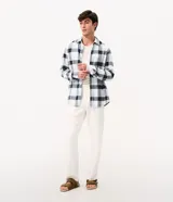 Camisa de corte comfort confeccionada en algodón, con estampado de cuadros en tonos marrón, beige y azul. Presenta cuello camisero, mangas largas con puños abotonados y cierre frontal con botones.