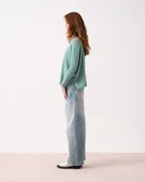 Sweater de cuello alto en punto acanalado, color verde menta, con mangas ajustadas y cuerpo amplio y suelto.