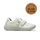 Championes deportivos casuales de cuero vacuno con textura granulada, color blanco. Presentan cierre mediante tiras de velcro, suela de goma antideslizante y detalle de logo metálico dorado en el lateral.