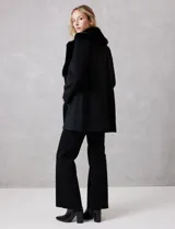 Tapado de lana Michael Kors con doble abotonadura y cuello de solapa ancha revestido en piel sintética. Presenta cierre frontal con seis botones grabados, bolsillos laterales de ojal y silueta de corte recto a la altura del muslo.