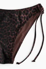 Vedetina de bikini con estampado animal print de leopardo, tiro estándar y tiras laterales para atar.
