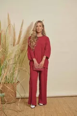 Conjunto de dos piezas color bordó, compuesto por una blusa de manga 3/4 y cuello redondo, y un pantalón de corte recto. Ambas prendas tienen una textura plisada.