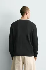 Jersey relaxed fit de punto acanalado color marrón oscuro, con cuello redondo tipo panadera y cierre frontal de tres botones. Tiene manga larga y efecto lavado.