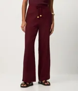 Pantalón de corte recto confeccionado en mezcla de viscosa y lino. Presenta cintura elástica con cordón ajustable y bolsillos laterales.
