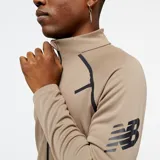 Campera deportiva color beige con cierre frontal completo, cuello alto y bolsillos laterales. Presenta detalles en negro en hombros y mangas.