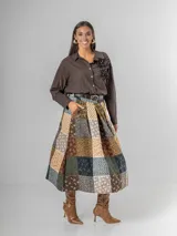 Falda midi de paño con estampa patchwork de inspiración escocesa, confeccionada en mezcla de lana. Presenta pinzas frontales, cintura elástica para mayor comodidad y un cinto desmontable a tono.