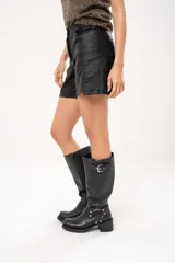 Short negro de tiro alto confeccionado en gabardina stretch metalizada, con bolsillos laterales y cierre frontal con cremallera y botón.