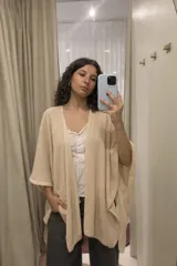 Ruana abierta de tejido liviano con caída fluida y textura sutil, diseñada con un corte amplio y versátil que envuelve el cuerpo.