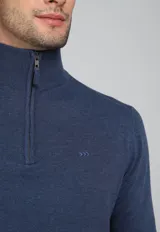 Sweater color ladrillo de tejido de punto, con cuello alto y cierre metálico a la mitad del pecho.