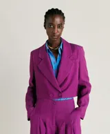 Blazer corto color fucsia de lino y viscosa, con solapas de muesca, cierre cruzado con dos botones, bolsillo en el pecho y forro completo.