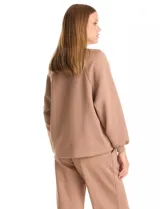 Buzo de corte holgado con sisa raglán y mangas largas con puños ajustados. Presenta un estampado sutil de animal print tono sobre tono y escote redondo a la base.