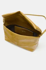 Bolso de mano tipo sobre color mostaza, con diseño acolchado y costuras geométricas. Cuenta con cierre imantado y asa tipo bandolera extraíble.