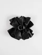 Broche para el pelo con diseño de moño grande confeccionado en tela satinada negra, montado sobre una pinza tipo clip.