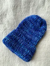 Gorro de lana tejido a mano, color azul con detalles en celeste y blanco. Diseño con punto elástico y dobladillo.