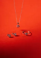 Cadena de eslabones tipo forcé con dije en forma de corazón, compuesto por una piedra central de zirconia rodeada por un marco de pequeñas circonias engastadas.