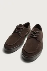 Mocasines estilo náutico de piel con acabado serraje, en color tostado, con cordones y suela de goma a contraste.