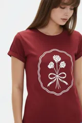 Remera de algodón color beige, de manga corta con vuelta, cuello redondo y estampa frontal de flores con lazo en tonos azules y celestes.