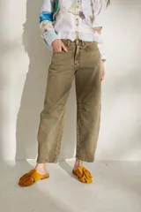 Jean barrel de tiro medio y corte holgado en las piernas, color verde militar, confeccionado en algodón. Presenta costuras decorativas a la altura de las rodillas y aberturas frontales en los tobillos.