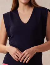 Buzo tejido en hilado fino color beige, con escote en V y sin mangas.