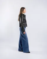 Campera estilo motero de símil cuero color negro, con cuello alto, cierre frontal asimétrico, bolsillos con cierre y detalles acolchados en los hombros.