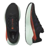 Championes de trail running Salomon DRX Defy Grvl, color negro con detalles en naranja y entresuela verde menta, diseñados con soporte y ligereza para correr en caminos de grava y asfalto.