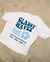 Remerón blanco de algodón con estampado en el frente que dice "Glassy Waves", "Good Vibes", una flor de hibisco y las fechas "1971. 1982. 1999" en color celeste y azul.