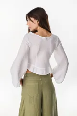 Top de lino italiano color beige, con escote en V, mangas abullonadas y cordón ajustable en el centro del frente.