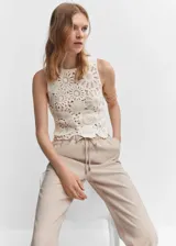 Pantalón recto de corte fluido, color beige, con cintura elástica y lazo ajustable. Cuenta con dos bolsillos laterales y diseño de estilo jogger.