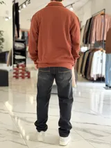 Buzo de felpa color beige con medio cierre frontal y cuello alto. Presenta estampado frontal con texto en contraste y diseño de estilo urbano.