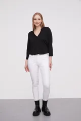 Pantalon jean de corte skinny y calce medio, color blanco, con bolsillos laterales y traseros.