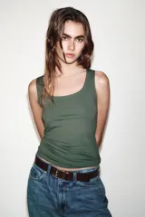 Camiseta blanca ajustada de poliamida con tirantes anchos y escote redondo.