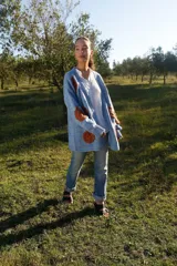 Cárdigan celeste pálido de lana merino con bordados florales color ladrillo hechos a mano.