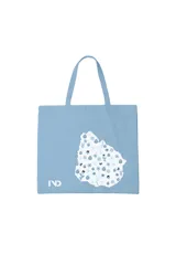 Bolso tipo tote de tela celeste con estampa del mapa de Uruguay relleno de flores y el logo de la marca IND en la esquina inferior izquierda.