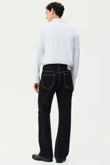 Camisa H&M de corte slim fit, color blanco, confeccionada en tejido elástico con cuello italiano y cierre frontal de botones.