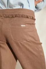 Pantalón morado de corte acampanado con volados decorativos en la cintura y en el ruedo.