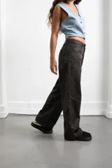 Pantalón de jean con estampado animal print en tonos oscuros, de corte recto y tiro medio. Cuenta con bolsillos traseros y etiqueta de cuero sintético con el logo de la marca en la cintura.