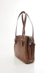Cartera de hombro estructurada color negro, confeccionada en 100% cuero vacuno con textura en relieve tipo reptil. Cuenta con asas largas ajustables mediante hebillas metálicas plateadas, cierre superior y el logo de la marca grabado en la parte frontal.