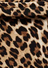 Vestido corto de manga larga con diseño off-shoulder y cuello barco. Presenta un estampado de leopardo en tonos marrones y negros, con un corte entallado y tejido fluido.